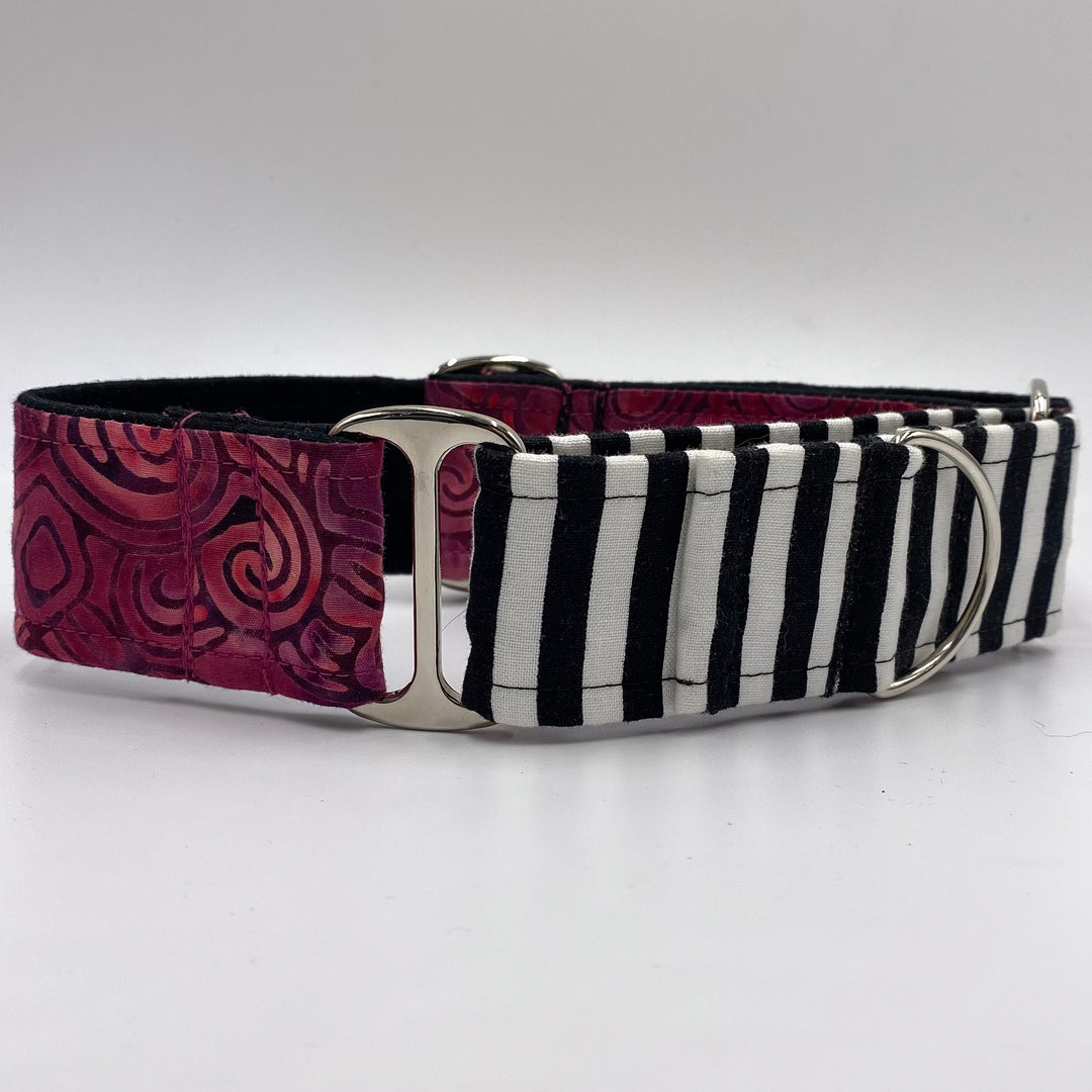 A stylish martingale dog collar featuring two different fabric patterns. One half is black and white vertical stripes, and the other half is a rich burgundy with a velvety texture and swirled patterns. The collar includes shiny silver metal rings and an adjustable slider for fitting.